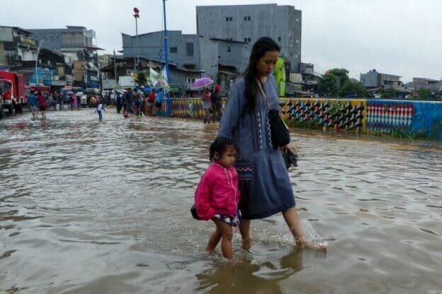 A-woman-and-her-daughter-walk-through-a-flooded-road-after-heavy-rain-in-Jakarta-on-Feb.-25-2020.-Bay-Ismoyo_Getty-Images_Greeneration-Foundation-1024x683-1-624x416-1.jpg